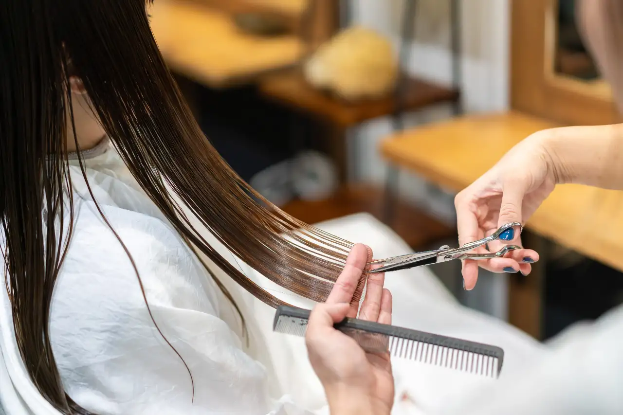 ロングヘアのカットを行うスタイリストの手元